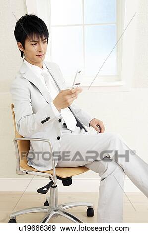 Stock Photo - Office worker checking a cell phone. Fotosearch