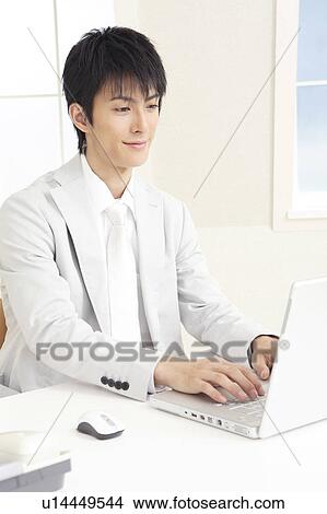 Office worker operating a laptop PC View Large Photo Image Picture - Office worker operating a laptop PC. Fotosearch