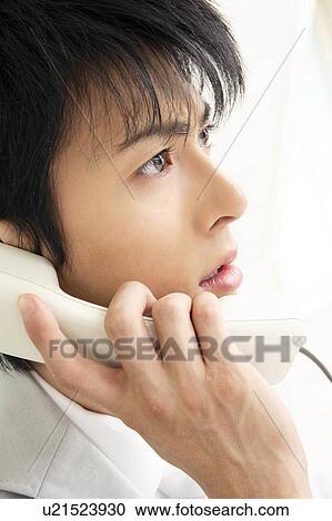 Stock Image - Office worker talking with phone. Fotosearch