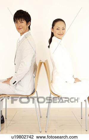 Stock Image - Office workers sitting on a chair. Fotosearch