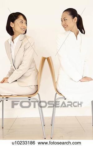 Stock Photograph - Office workers sitting on a chair. Fotosearch
