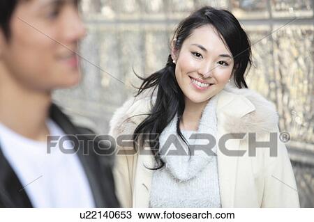 Stock Image - Japanese woman looking at young man. Fotosearch