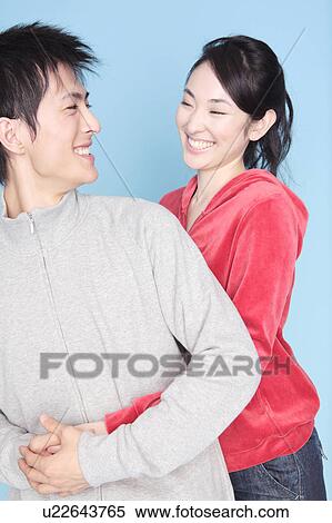 Stock Photography - Woman embracing a lover from back. Fotosearch
