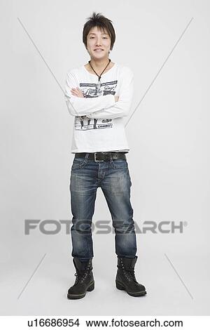 Picture - Portrait of a young man standing with arms crossed. Fotosearch