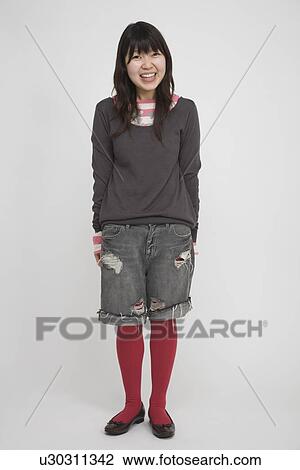 Stock Image - Portrait of a young woman standing. Fotosearch