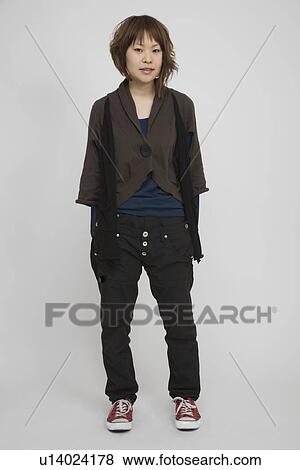 Stock Photo - Portrait of a young woman standing. Fotosearch