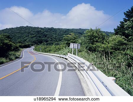 Picture - Winding road through mountain. Fotosearch