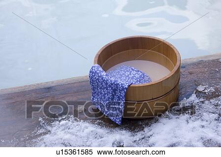 Stock Photography - Hot spring beside towel on wooden tub beside hot spring. Fotosearch