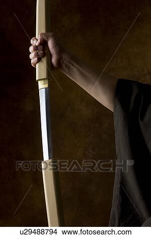 Picture - Japanese man holding sword. Fotosearch