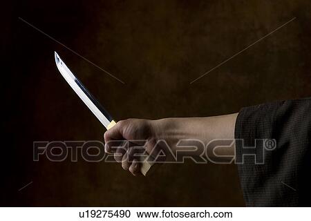 Japanese man holding sword View Large Photo Image Stock Image - Japanese man holding sword. Fotosearch