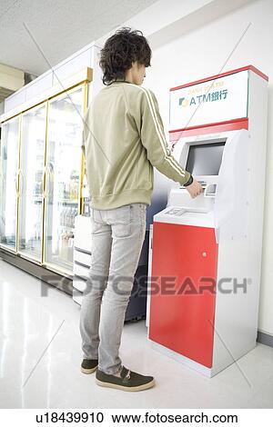 Customer at convenience store operating ATM View Large Photo Image Stock Image - Customer at convenience store operating ATM. Fotosearch