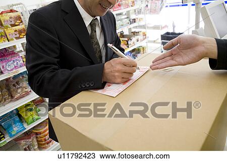 Customer at convenience store writing on slip View Large Photo Image Stock Image - Customer at convenience store writing on slip. Fotosearch