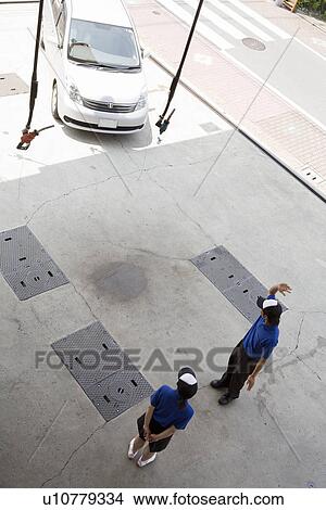 Gas station clerk guiding car View Large Photo Image Picture - Gas station clerk guiding car. Fotosearch