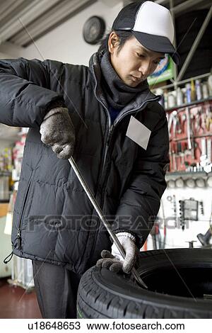 Gas station clerk maintaining tire View Large Photo Image Stock Image - Gas station clerk maintaining tire. Fotosearch
