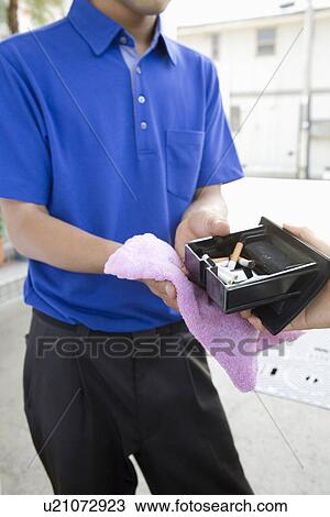 Stock Image - Gas station clerk receiving ashtray. Fotosearch
