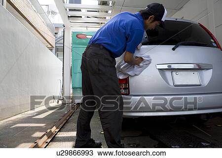 Stock Image - Gas station clerk washing car. Fotosearch