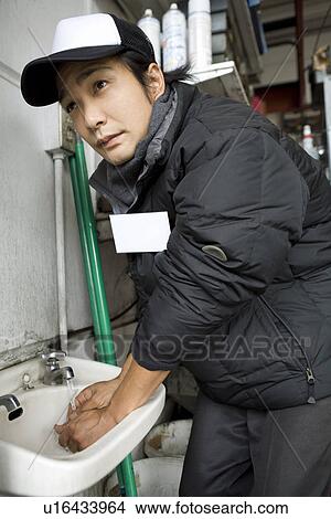 Gas station clerk washing hands View Large Photo Image Picture - Gas station clerk washing hands. Fotosearch