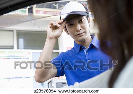 Gas station clerk welcoming customer View Large Photo Image Picture - Gas station clerk welcoming customer. Fotosearch