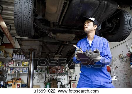 Stock Image - Mechanic checking car. Fotosearch