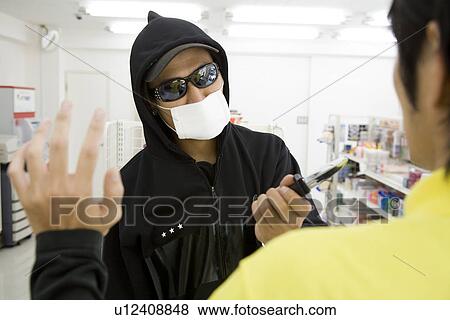 Stock Photo - Robber threatening convenience store clerk . Fotosearch
