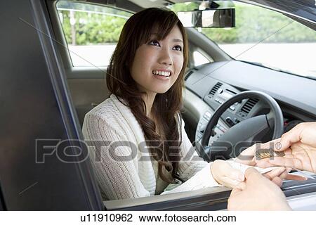 Young woman in car receiving change View Large Photo Image Stock Image - Young woman in car receiving change. Fotosearch