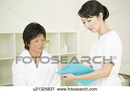 Stock Photo - Massage therapist counseling man. Fotosearch