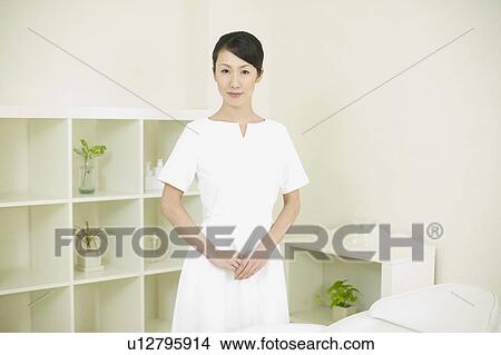 Picture - Massage therapist welcoming guest. Fotosearch