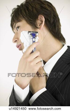 Stock Image - Young businessman shaving. Fotosearch