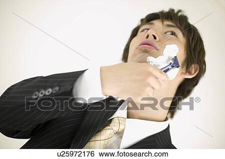 Young businessman shaving View Large Photo Image Stock Photograph - Young businessman shaving. Fotosearch