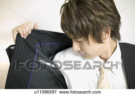 Stock Photo - Young businessman sniffing his underarm. Fotosearch