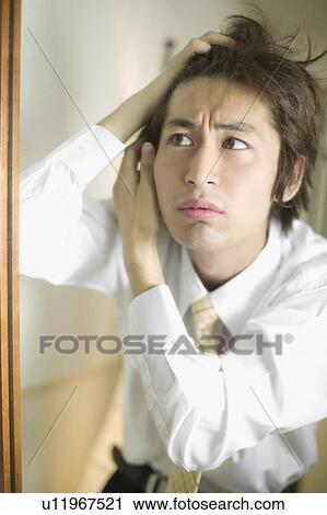 Young businessman worrying about his hair View Large Photo Image Stock Image - Young businessman worrying about his hair. Fotosearch