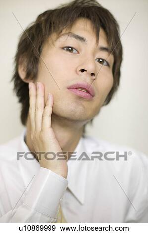 Stock Photo - Young businessman worrying about his beards. Fotosearch