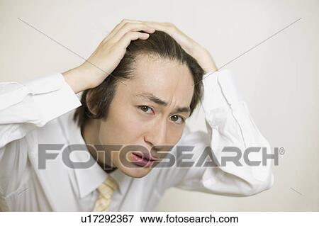 Stock Photo - Young businessman worrying about his hair. Fotosearch
