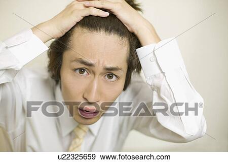 Stock Photo - Young businessman worrying about his hair. Fotosearch