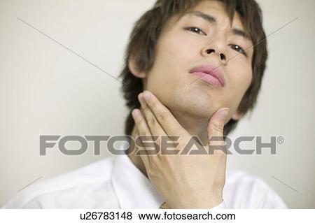 Stock Photo - Young businessman worrying about his beards. Fotosearch