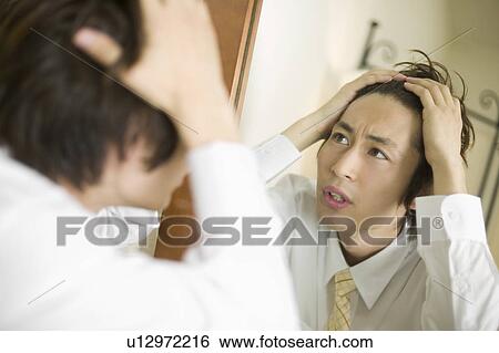 Young businessman worrying about his hair View Large Photo Image Stock Photograph - Young businessman worrying about his hair. Fotosearch