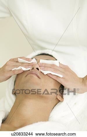 Young man receiving facial treatment View Large Photo Image Picture - Young man receiving facial treatment. Fotosearch