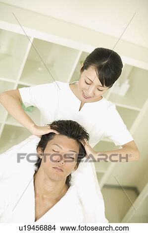 Picture - Young man receiving hair restoration massage. Fotosearch