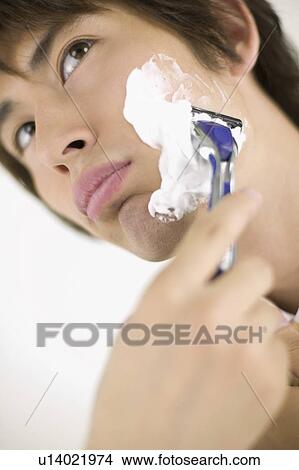 Picture - Young man shaving. Fotosearch