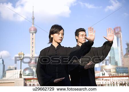 Stock Photo - China, Shanghai, Pudong, Business district, skyline, young man and woman doing martial arts on the Bund. Fotosearch