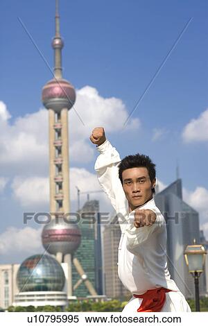 Stock Photography - China, Shanghai, Pudong, Business district, skyline, young man doing martial arts on the Bund. Fotosearch