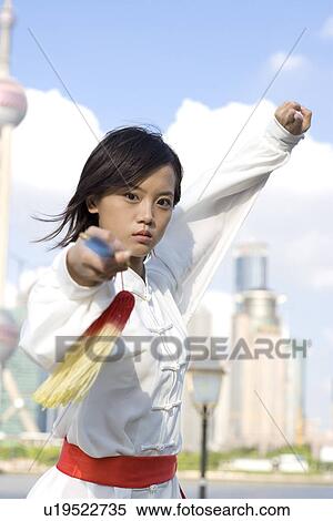 Stock Photography - China, Shanghai, Pudong, Business district, skyline, young woman doing martial arts on the Bund. Fotosearch