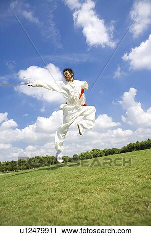 Man practicing martial arts with sword in the air View Large Photo Image Stock Image - Man practicing martial arts with sword in the air. Fotosearch