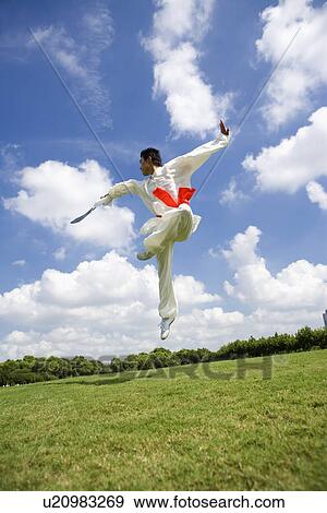 Man practicing martial arts with sword in the air View Large Photo Image Stock Photo - Man practicing martial arts with sword in the air. Fotosearch