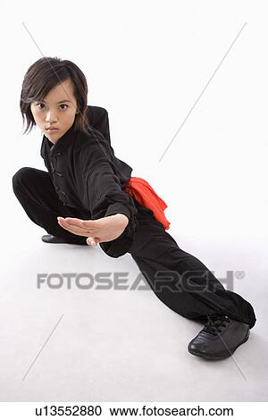 Stock Image - Woman practicing martial arts in studio shot. Fotosearch