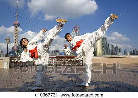 Stock Image - Young man and woman doing martial arts on the Bund. Fotosearch