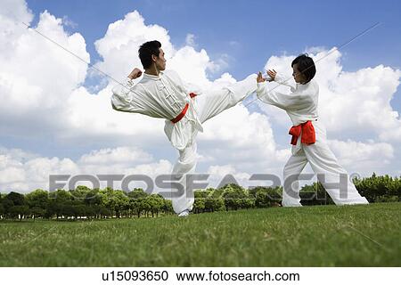 Stock Image - Young man and woman practicing martial arts. Fotosearch