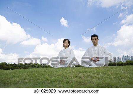Stock Photo - Young man and woman with legs crossed. Fotosearch
