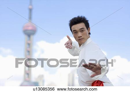 Stock Photograph - Young man doing martial arts, Orient pearl tower in the background. Fotosearch