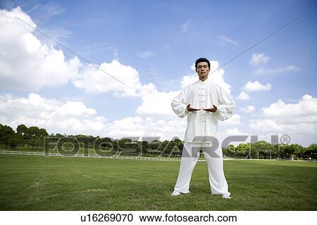 Stock Image - Young man inhaling while practicing martial arts. Fotosearch